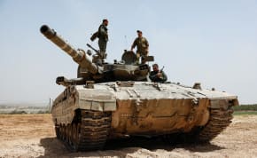  IDF soldiers operate atop a tank near the Gaza border, as seen from Israel, May 21, 2024