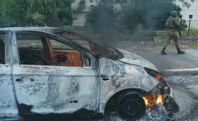  A SOLDIER passes by a burned-out car in Kiryat Shmona in the aftermath of a rocket attack on the northern Israeli city, earlier this month. Since the conflict began, northern Israel has come under repeated rocket and drone attacks from Lebanon, the writer notes.