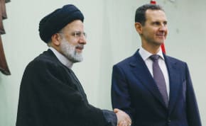  SYRIA’S PRESIDENT Bashar Assad shakes hands with Iranian President Ebrahim Raisi during the signing of a cooperation agreement in Damascus, last year. The ICC has never issued an arrest warrant against Ayatollah Khamenei or Assad, the writer points out.
