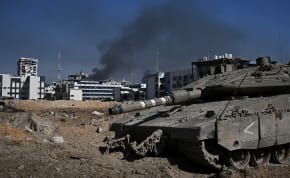  A view shows an Israeli tank as smoke rises over buildings, amid the ongoing conflict between Israel and the Palestinian Islamist group Hamas, in the Gaza Strip, February 8, 2024. 