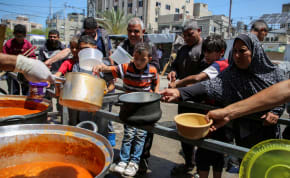  Palestinians gather to receive food cooked by a charity kitchen, amid shortages of aid supplies, after Israeli forces launched a ground and air operation in the eastern part of Rafah, as the ongoing conflict between Israel and Hamas continues, in Rafah, in the southern Gaza Strip May 8, 2024.