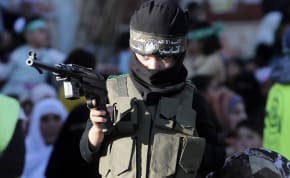  A Palestinian boy wearing the headband of Hamas's armed wing holds a toy gun during a rally honouring families of Palestinians, who were killed by Israeli forces during a 50-day war last summer, in Bureij refugee camp in the central Gaza Strip March 6, 2015. 