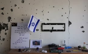  A view of an Israeli flag and other belongings inside a burnt house that has been abandoned for two months after the deadly October 7 attack by gunmen from Palestinian militant group Hamas from the Gaza Strip, in Kibbutz Beeri, southern Israel, December 7, 2023. 