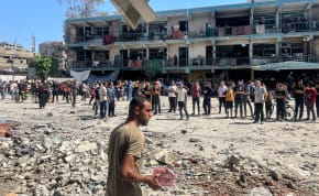  Palestinians inspect the site of an Israeli strike on a UNRWA school sheltering displaced people, amid the Israel-Hamas conflict, in Nuseirat refugee camp in the central Gaza Strip, June 6, 2024.