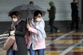 Iranian women wear protective masks to prevent contracting coronavirus, as they walk in the street i