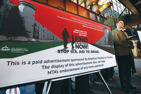  HATEM BAZIAN, chairman of American Muslims for Palestine, speaks in 2013 alongside one of the organization’s advertisements at a train station in New York City, accusing Israel of apartheid and calling for a stop to US aid.