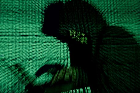 A man holds a laptop computer as cyber code is projected on him in this illustration picture taken on May 13, 2017.