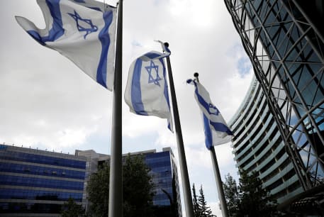  Israeli national flags flutter in front of an office tower at a business park also housing high tech companies, at Ofer Park in Petah Tikva, Israel August 27, 2020.