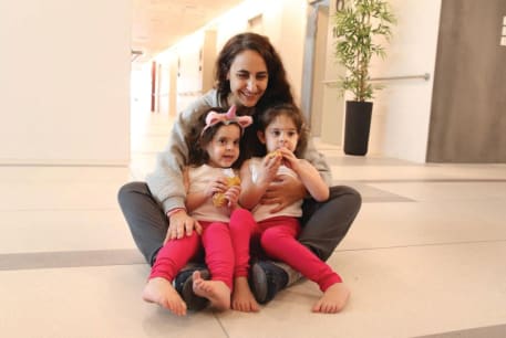  SHARON ALONI-CUNIO, 34, holds her twins Yuli Cunio, 3, and Emma Cunio, 3, at Schneider Children’s Medical Center after their release by Hamas.