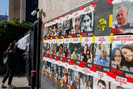  A woman stands next to posters with photos of hostages kidnapped in the deadly October 7 attack on Israel by the Palestinian Islamist group Hamas from Gaza, in Tel Aviv, Israel March 20, 2024. 