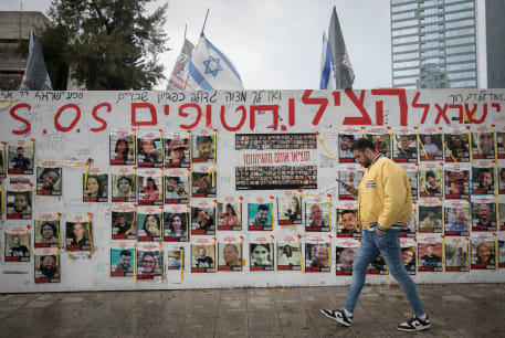  People walk by photographs of Israelis still held hostage by Hamas terrorists in Gaza, in Tel Aviv. March 19, 2024