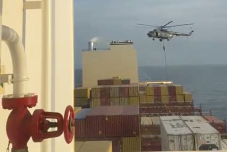  An official slides down a rope during a helicopter raid on MSC Aries ship at sea in this screen grab obtained from a social media video released on April 13, 2024. 