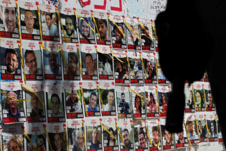 An Israeli soldier's rifle is silhouetted next to posters of hostages kidnapped during the deadly October 7 attack, in Tel Aviv, Israel, May 5, 2024
