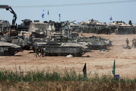  IDF soldiers gather next to tanks near the Israel-Gaza border, May 8, 2024