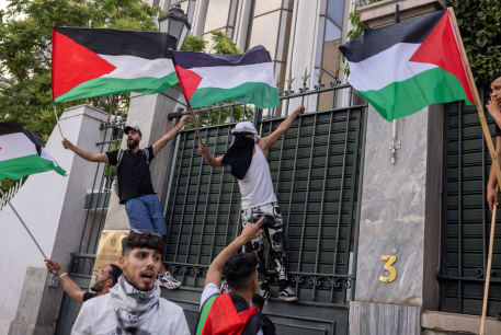  Demonstrators wave Palestinian flags at the entrance of the Egyptian embassy, in Athens, Greece, May 7, 2024