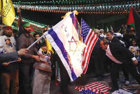  PROTESTERS BURN an Israeli and a US flag in Tehran, earlier this year. The Iranian cyber threat is especially troubling for the Jewish Diaspora, which Iran targets as part of its broader agenda, encapsulated in its chilling slogan: ‘Death to America, Death to Israel,’ says the writer. 