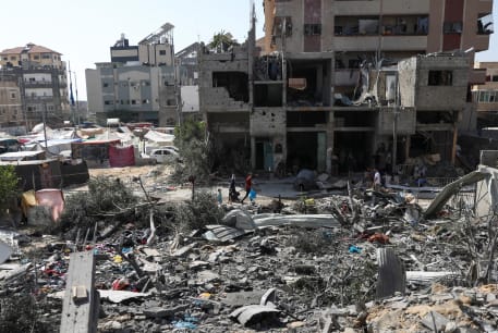 People walk among debris at the area where Israeli hostages were rescued on Saturday in Nuseirat refugee camp in the central Gaza Strip, June 9, 2024.
