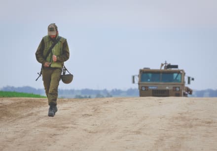  A SOLDIER walks near an IDF Artillery Corps staging area on the  border with Gaza