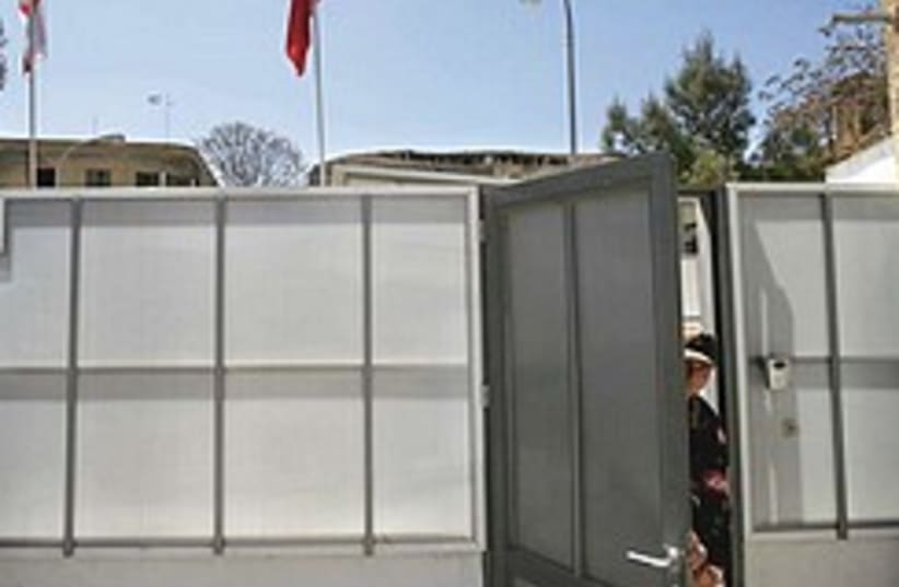 Turkish soldier opens door in temporary wall by UN (photo credit: AP)
