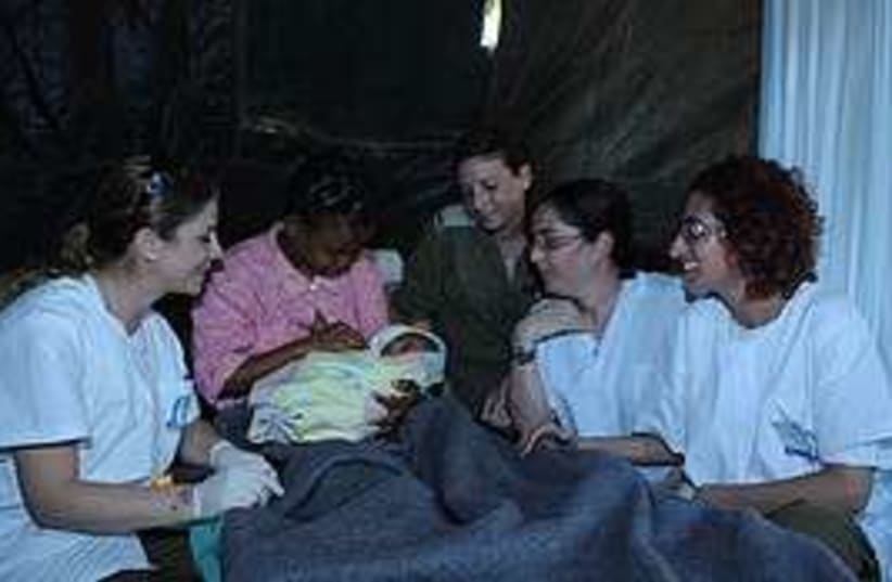 A mother holds her baby in Haiti's IDF field hospital,  (photo credit: IDF)