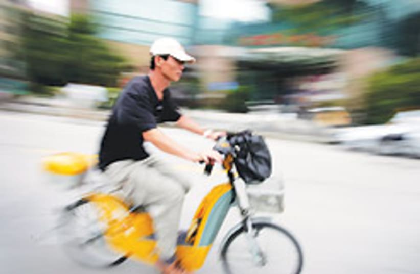 Commuters ride bicycles, mopeds and electric bicyc (photo credit: AP)
