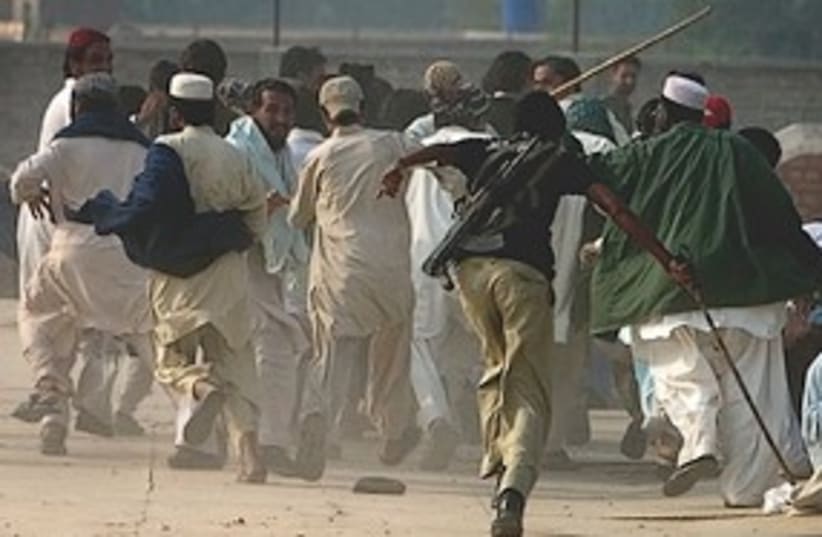 Pakistani police officer chases a mob 311 (photo credit: Associated Press)