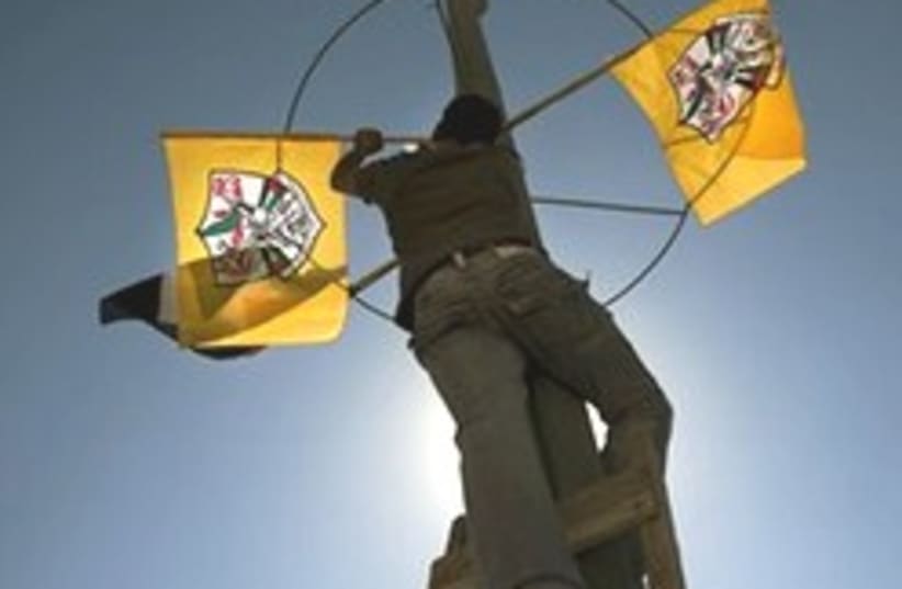 A man places Fatah flags in Bethlehem, Sunday (photo credit: AP)