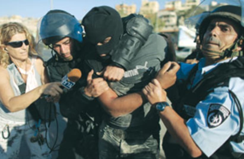 police detain masked Arab protester (photo credit: Associated Press)