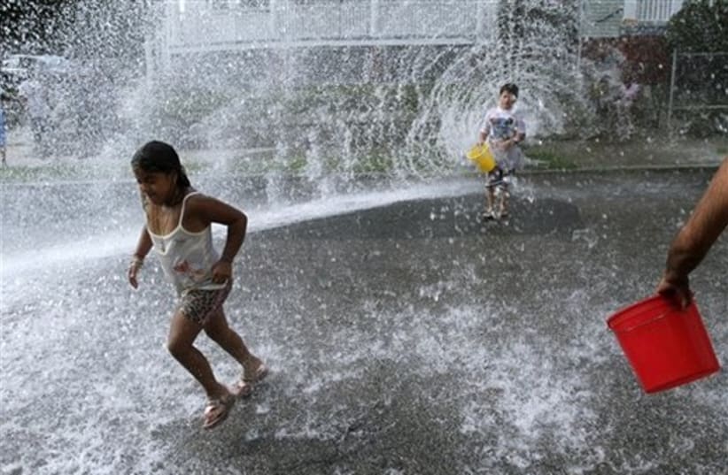 girl plays in water from fire hydrant (photo credit: AP)