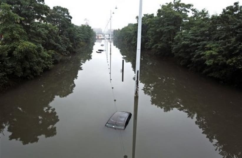 Vehicles are submerged in flood waters following heavy rain  (photo credit: AP)