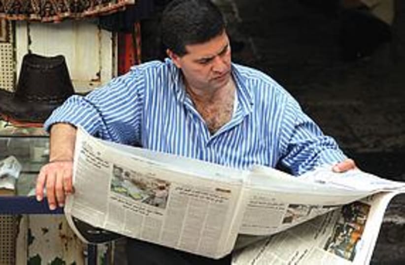 Man reads Arabic newspaper in J'lem (photo credit: Marc Israel Sellem)