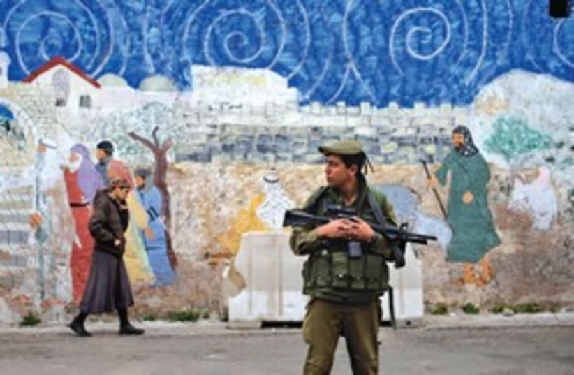 Soldier patrols in Hebron 311 (photo credit: ASSOCIATED PRESS)