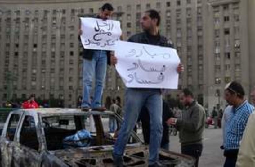 Egyptian protesters on burnt car 311 (photo credit: MELANIE LIDMAN)