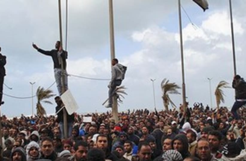 Libya protests men climbing 311 (photo credit: AP)