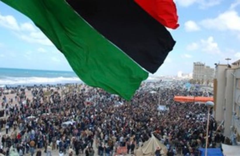 Libyan flag over protests (photo credit: AP)