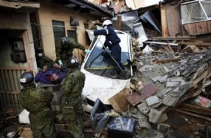 A body is pulled from rubble from Japan earthquake 311 (R) (photo credit: REUTERS/Damir Sagolj)