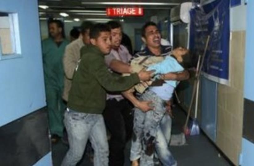 Palestinian boy carried into hospital Gaza injured 311 (R) (photo credit: REUTERS/Ismail Zaydah)