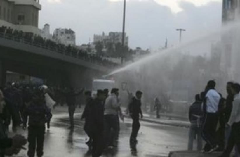 Jordanian protesters, police water canon 311 (R) (photo credit: REUTERS/Majed Jaber)
