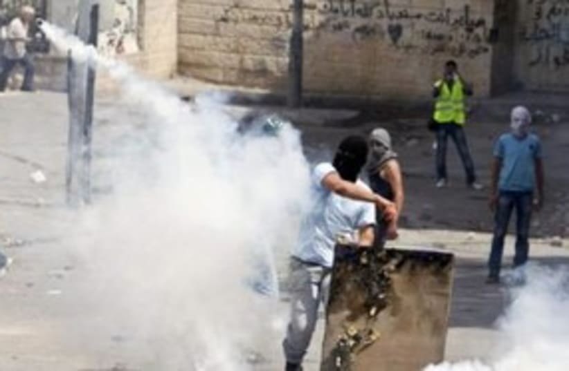 Palestinian throws back tear gas canister Silwan 311 (R) (photo credit: REUTERS/Nir Elias)