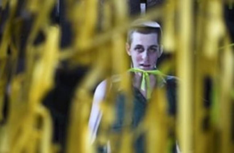 Gilad Schalit cutout seen through yellow ribons 311 (R) (photo credit: REUTERS/Amir Cohen)