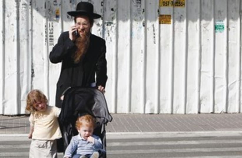 Haredi man with kids on mobile phone 311 (photo credit: REUTERS)