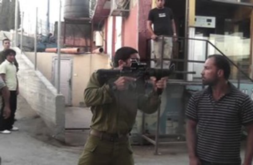soldier points gun in palestinian's face_311 (photo credit: B'Tselem)