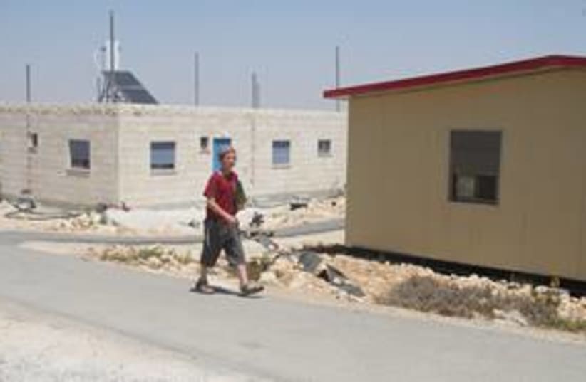 Boy walks past homes in W. Bank outpost of Migron 311 (photo credit: Tovah Lazaroff)