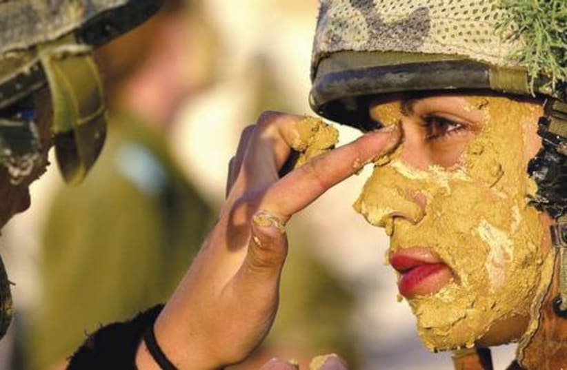 A female IDF soldier paints a comrade with mud. (photo credit: IDF)