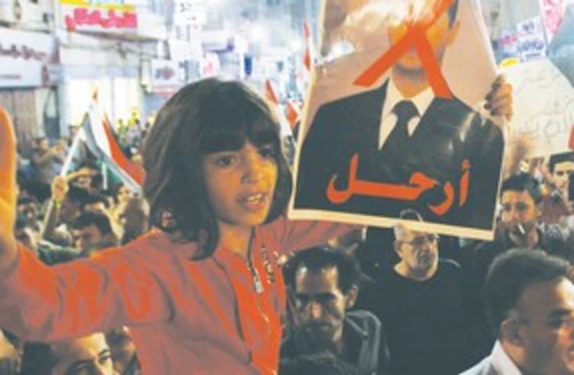 Girl holds poster of Assad311 (photo credit: Mohamad Torokman/Reuters)