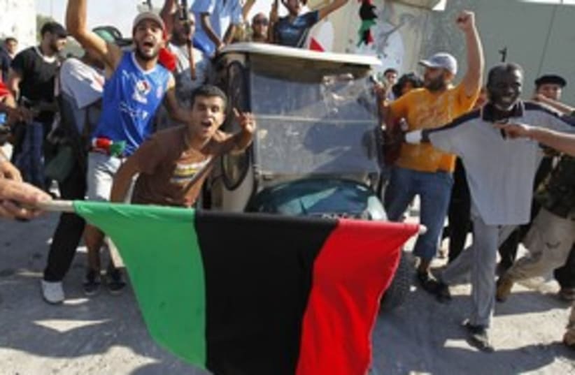 Libyan celebrate flag Tripoli_311 (photo credit: Reuters)
