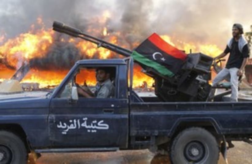 Libyan rebels ride along Bab al-Aziziyah (photo credit: Reuters)