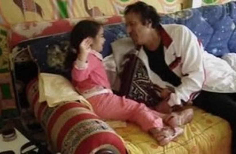 Gaddafi plays with granddaughter (photo credit: REUTERS)