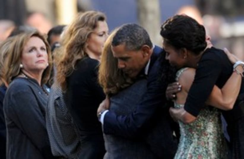 Barack and Michelle Obama hug  people (photo credit: REUTERS)