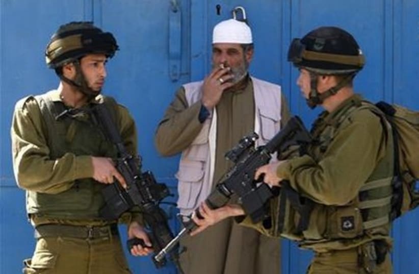 IDF soldiers, Palestinian man_521 (photo credit: Reuters)